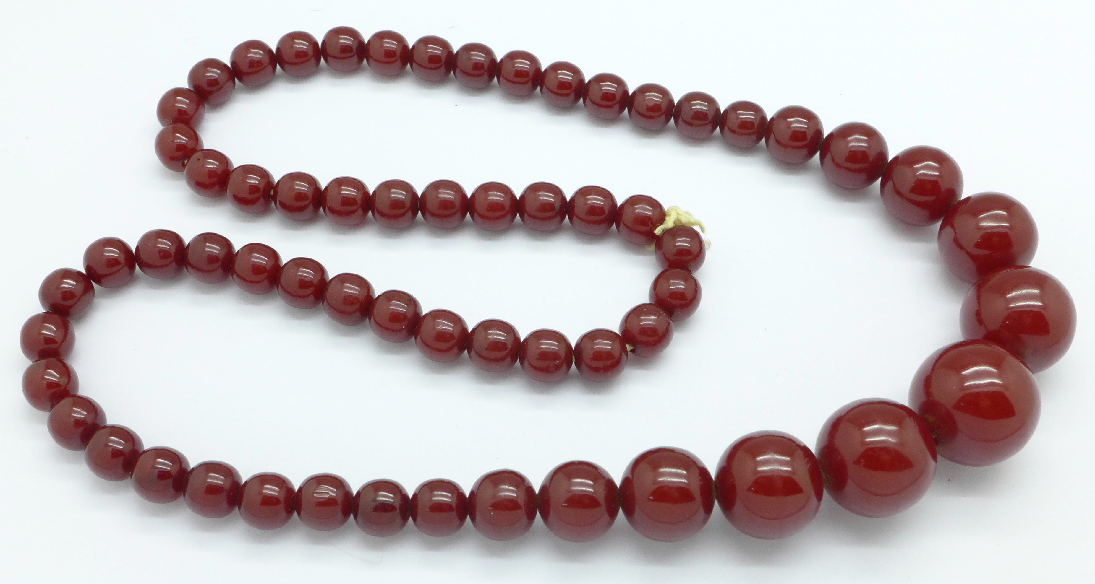 A set of sherry amber coloured beads, 69.