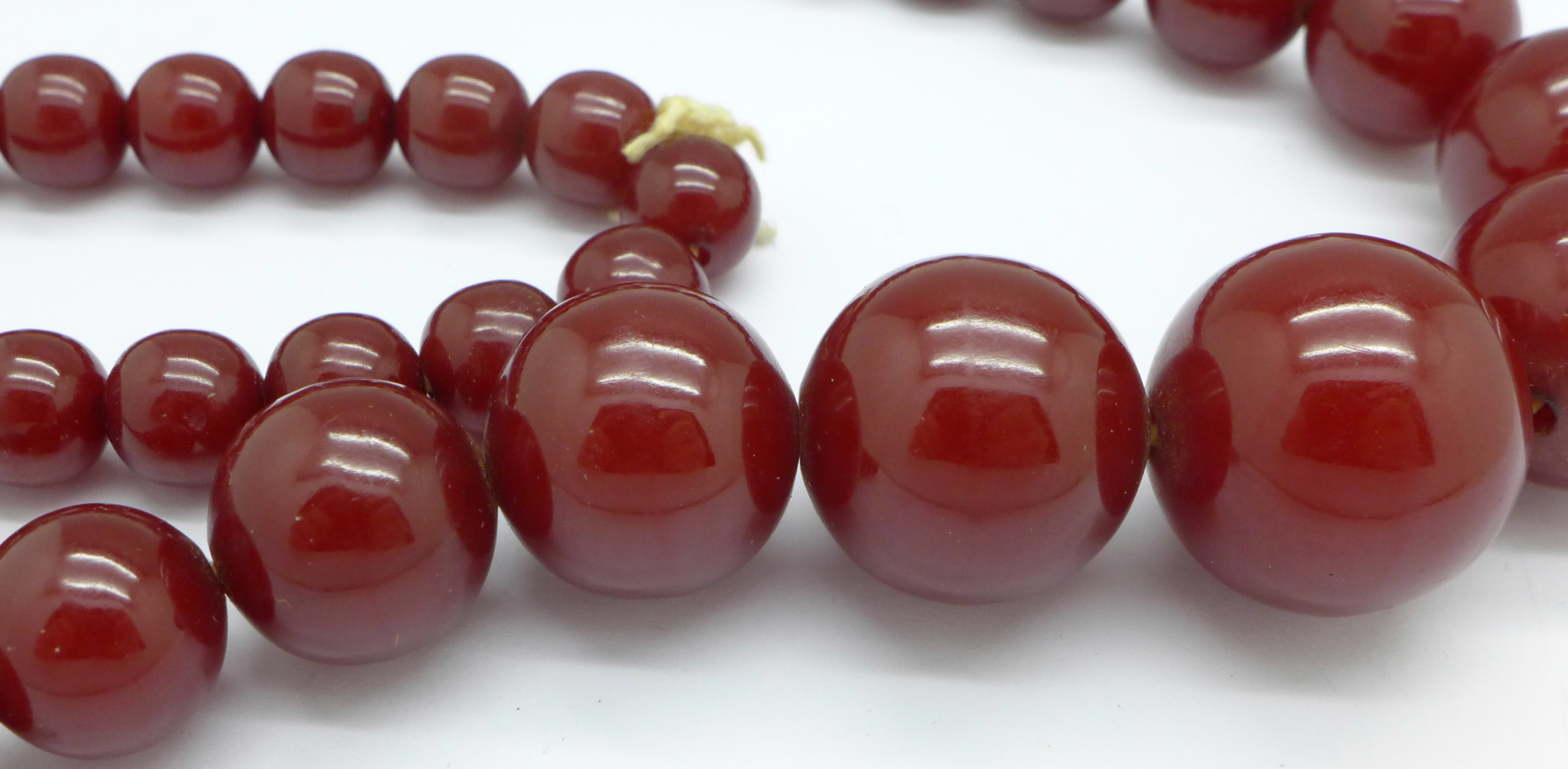 A set of sherry amber coloured beads, 69. - Image 2 of 2