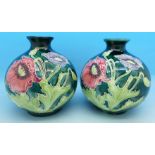 A pair of globular vases decorated with flowers, 6980, chip to base of one,