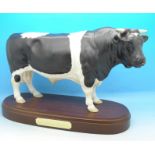 A Royal Doulton model friesian bull on stand