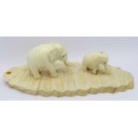 Two carved ivory elephants on a fossilised mammoth tooth base