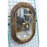 A small ebonised and parcel gilt framed mirror