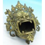 A Tibetan brass mask of a mythical creature