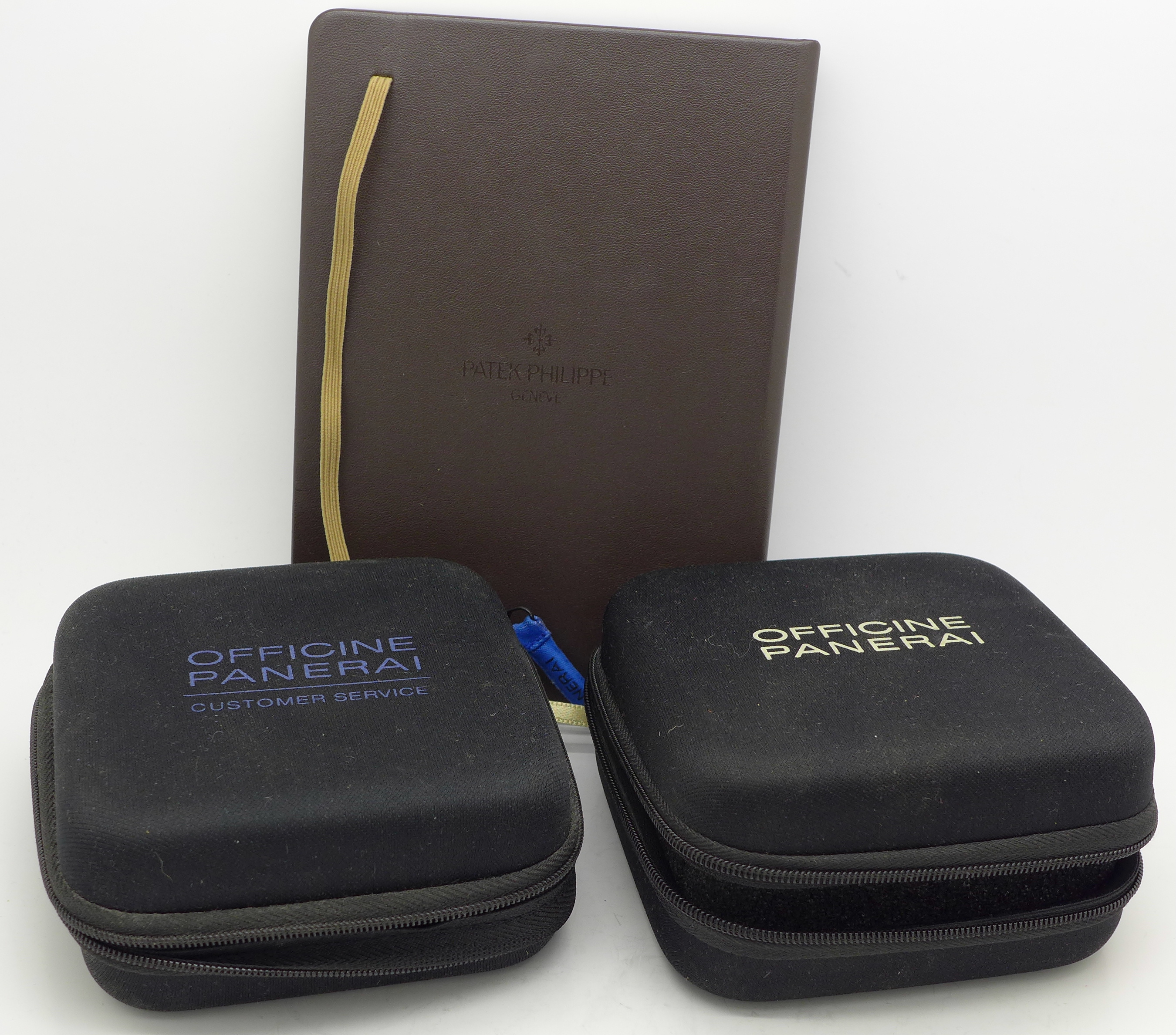 A Patek Philippe notebook and two cases marked Officine Panerai