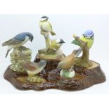 A Beswick display stand with five models of birds, including two Royal Worcester and one Beswick,