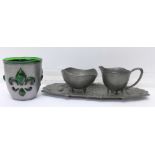 A green glass and metal mounted Arts and Crafts beaker and a pewter Arts and Crafts cream and sugar