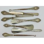Three silver handled shoe horns, two silver handled button hooks,