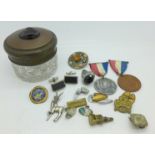 A glass jar with cameo set lid, with badges, cufflinks, brooches, etc.