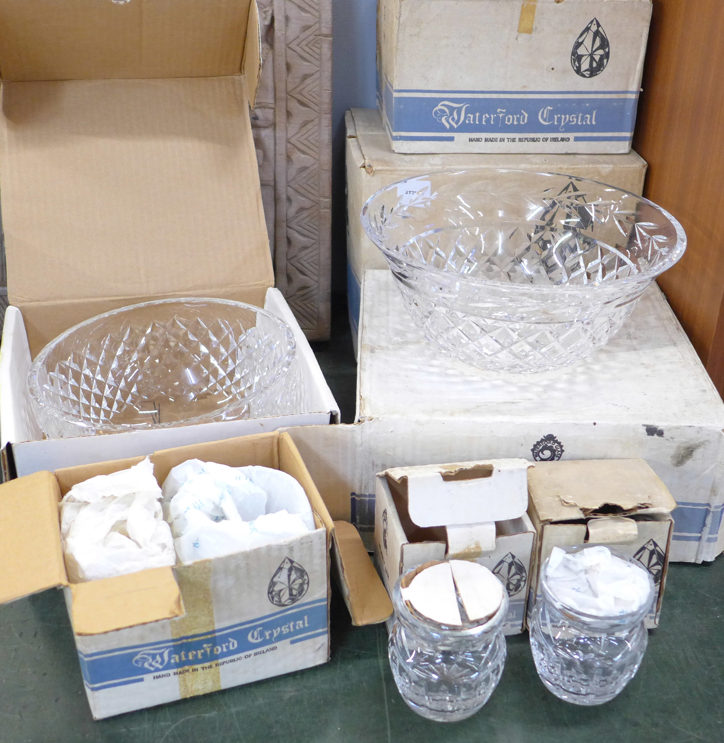 A collection of boxed Waterford crystal glass; two bowls, six hock, six claret, two honey jars,