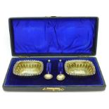 A pair of silver salts with spoons, cased,