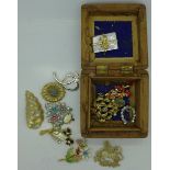 A carved wooden box and costume brooches