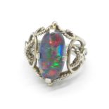 An oval cabochon cut black double opal set ring, in a white metal Arts and Crafts style setting,