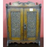 A Victorian carved oak smokers cabinet