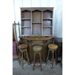 A carved oak bar and three stools