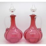 A pair of cranberry glass decanters with glass stoppers