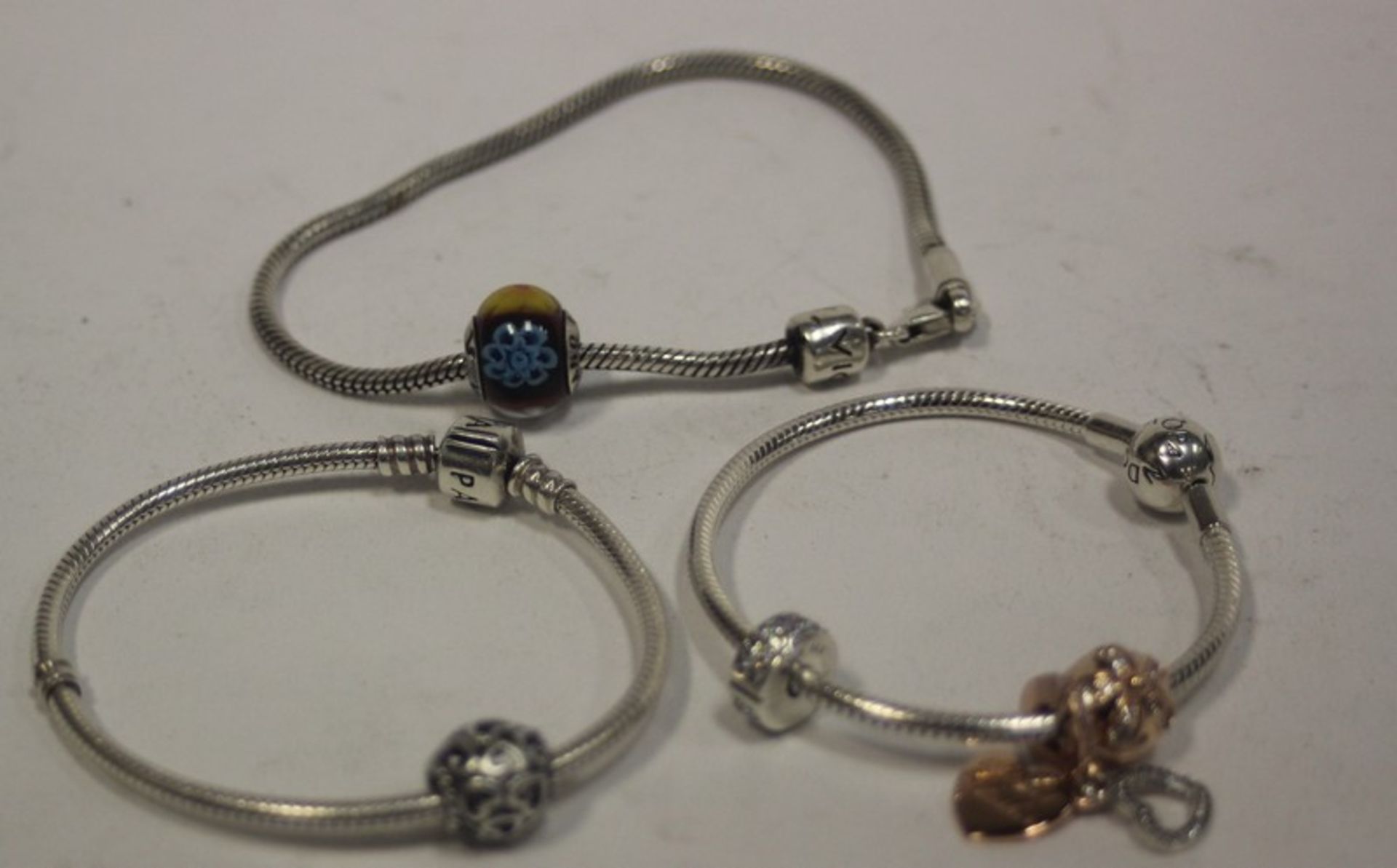 Three Pandora bracelets and five Pandora charms.
