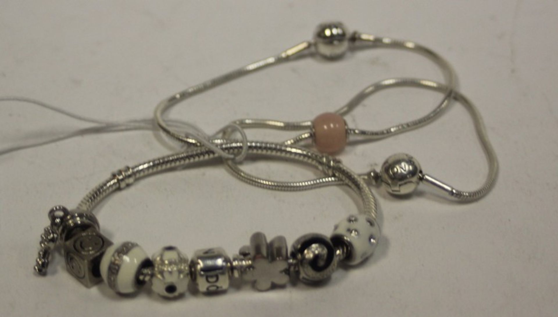 Three Pandora bracelets and seven Pandora charms.