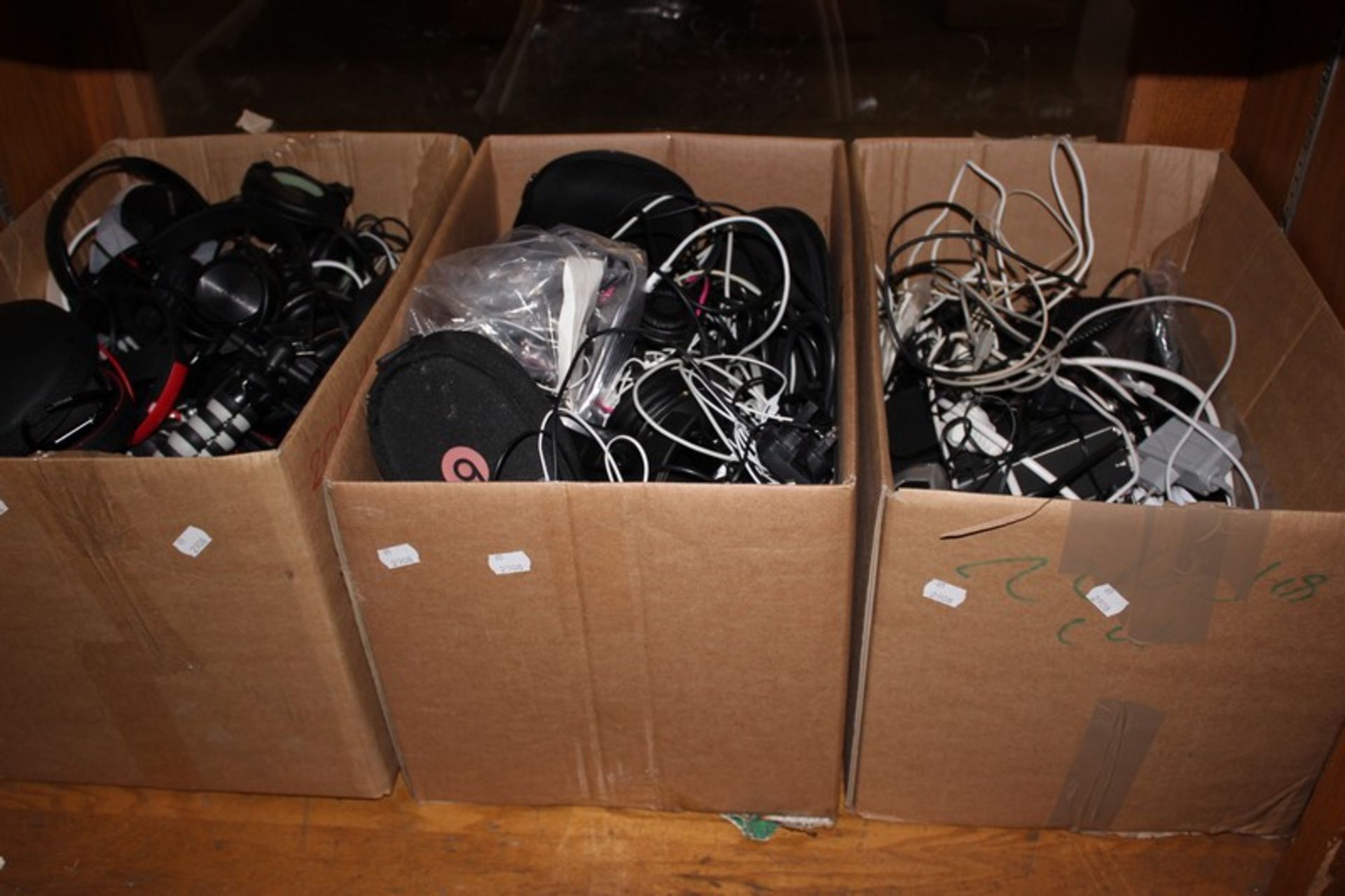 Three boxes of headphones and electrical items and wires etc.