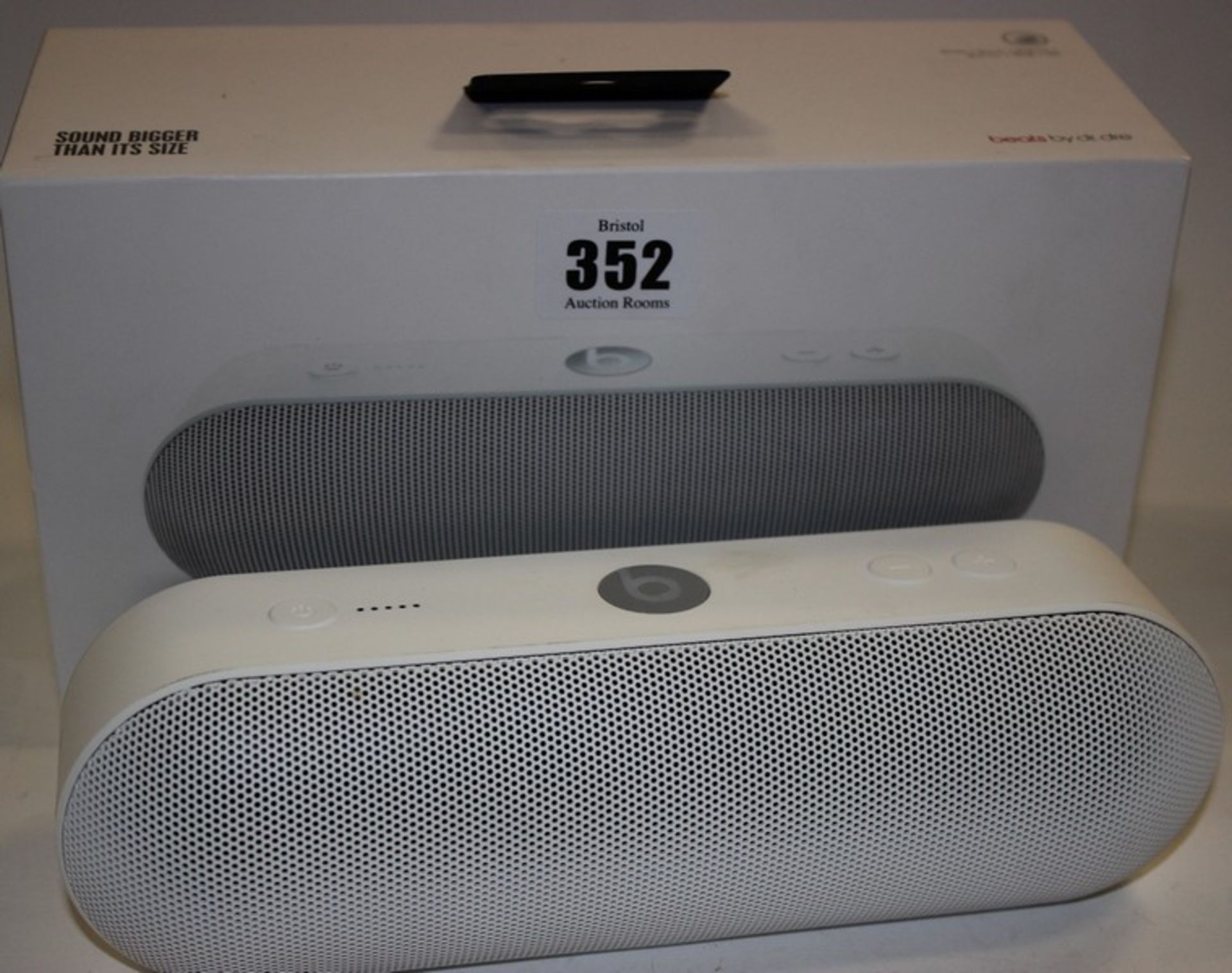 A white Beats Pill speaker with box.