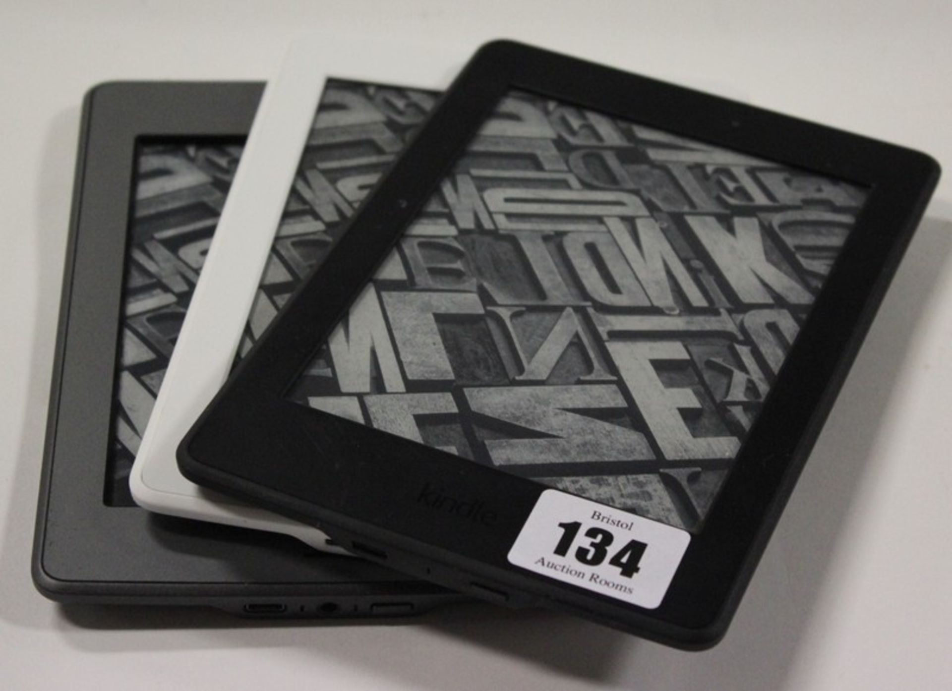 Two Amazon Kindle Paperwhite 3 (2015) and an Amazon Kindle 5/Touch (2012).