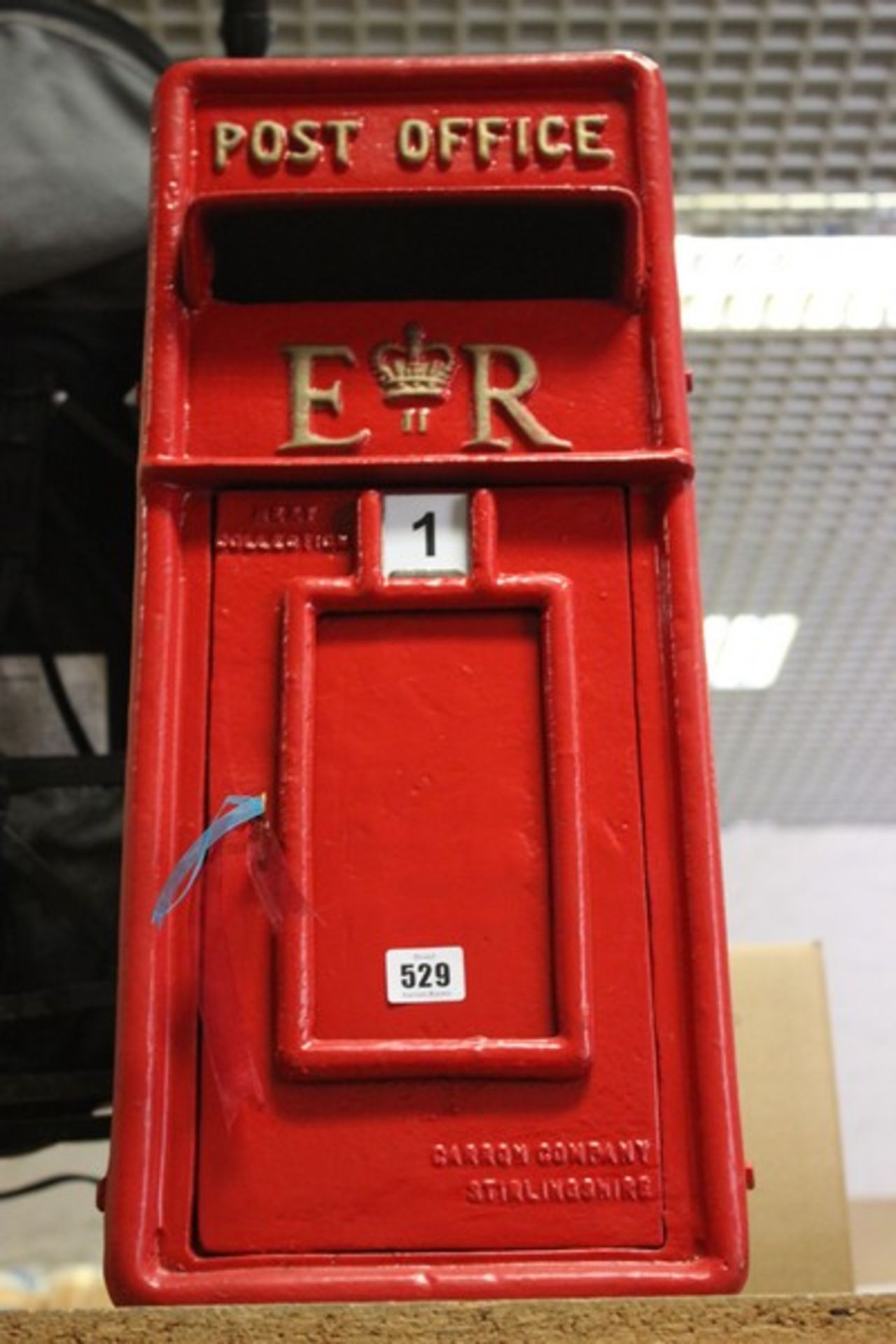 A reproduction red ER post box with key.