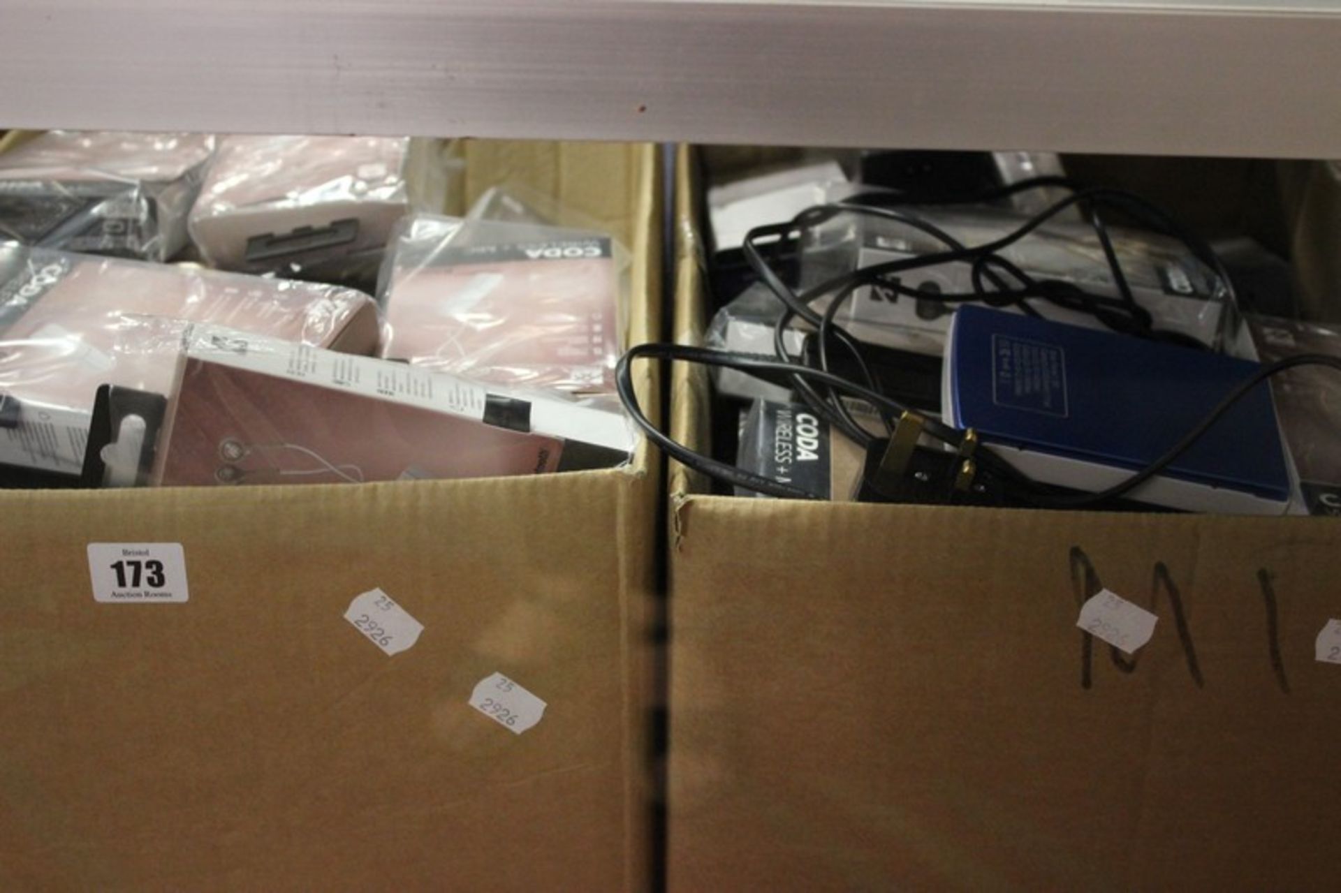 Two boxes of electrical items/headphones and phone/tablet cases.