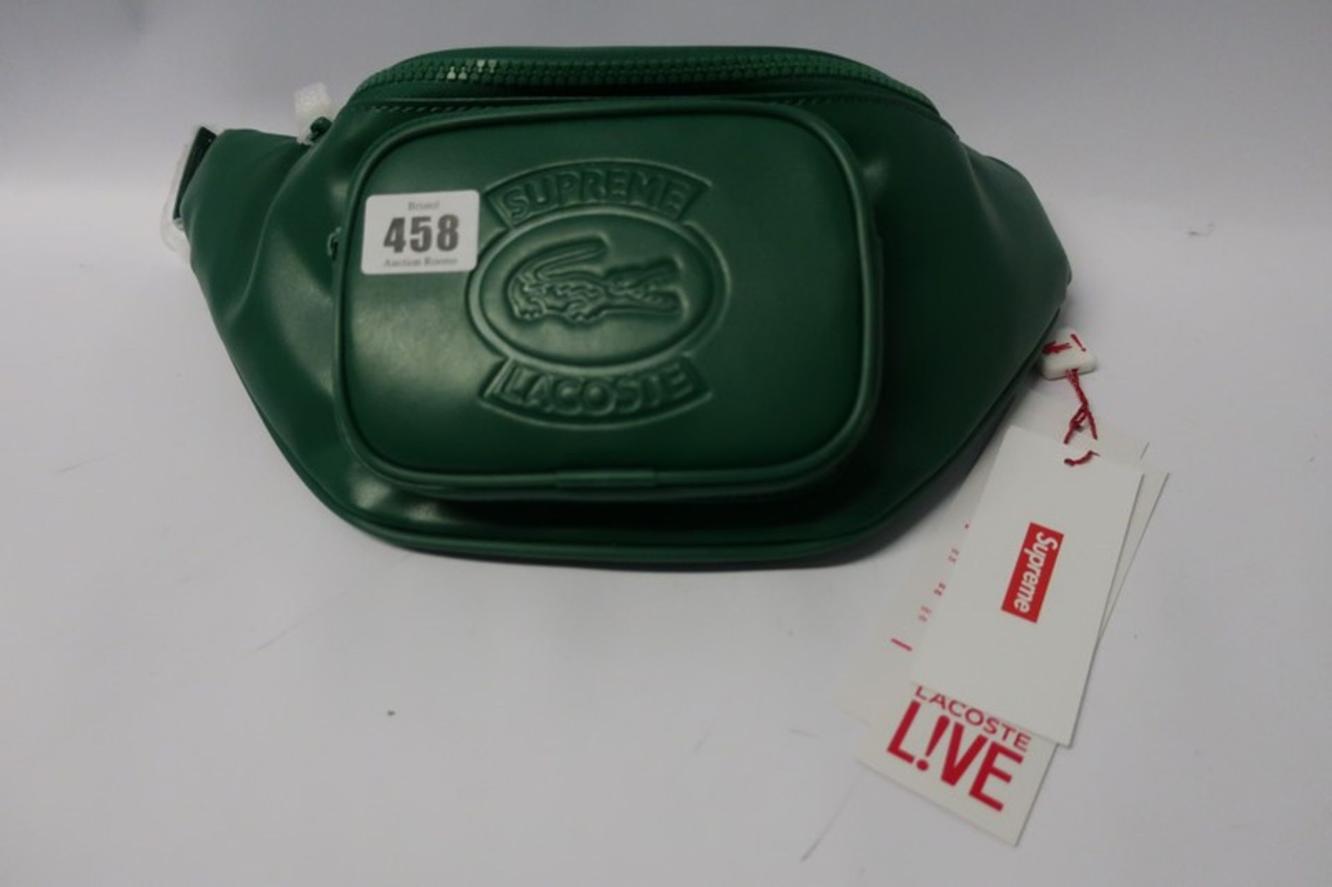 A Supreme Lacoste waist bag in green.