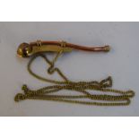 A copper and brass bosun's whistle on a chain with copper anchor decoration to end