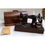A early 20th century singer sewing machine in wooden carry case