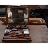 A wooden easel with a boxed set of oil paints including a palette