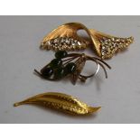 Three brooches: one in the shape of a leaf,