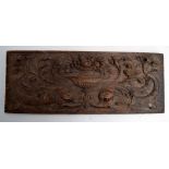 A renaissance style walnut panel in the mannerist taste carved with an urn of fruit and two