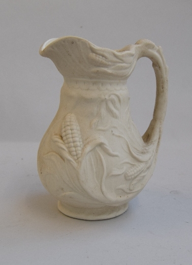 A biscuit porcelain jug displaying maize and stalks inscribed to base TBM, MMA, 20cmH,
