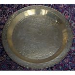 Three Islamic beaten brass trays - the largest 90cmD