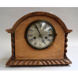 An oak mantle clock with key and pendulum