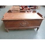 A camphor wood chest with hinged lid raised on turned legs,