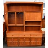 A large midcentury Nathan sideboard/unit with shelf above two glazed cupboard doors beside a drop