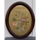 A framed silk embroidery of flowers in oval frame 35 x 47cm