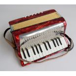 A Hohner Minion II miniature piano accordion with tune book