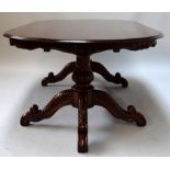 A large one piece dining table on two pedestal tripod carved supports,