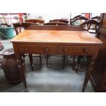 A mahogany side table with turned bobbin legs on casters, two short drawers and a backboard,