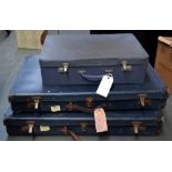 Three large blue luggage travel suitcases with associated labels