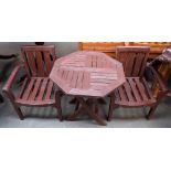 A set of children's garden furniture comprising two wooden armchairs and a wooden slatted table