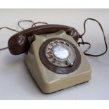 A vintage rotary telephone in brown and green, with stickers to base one reading 'Tele 8746 G B.T.