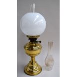 A late 19th century brass mounted oil lamp, complete with glass shade and two chimneys,