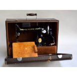 A vintage Singer portable sewing machine with accessories and carry case; Model No.