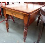 A pine kitchen table with end drawer and drop sides on turned legs,