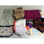 Box of old textiles including tablecloths, curtains and pieces of velvet.