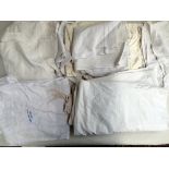 A collection of old linen bedding, including embroidered bed cover, sheet with cutwork border,