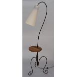 A modern French standard lamp with conical shade and bent metal stand with wooden shelf,